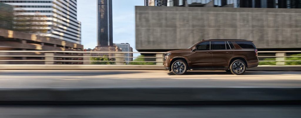 A brown 2022 Chevy Tahoe driving to look at SUVs for sale in San Antonio.