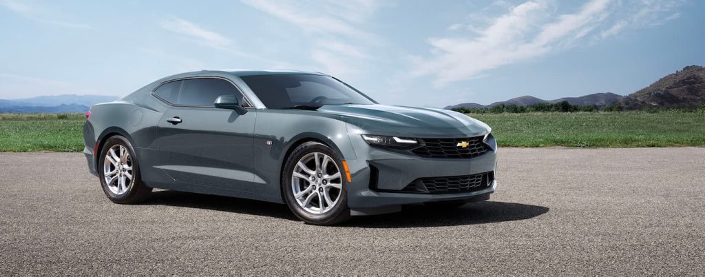 Side view of a grey 2023 Chevy Camaro parked in the countryside.