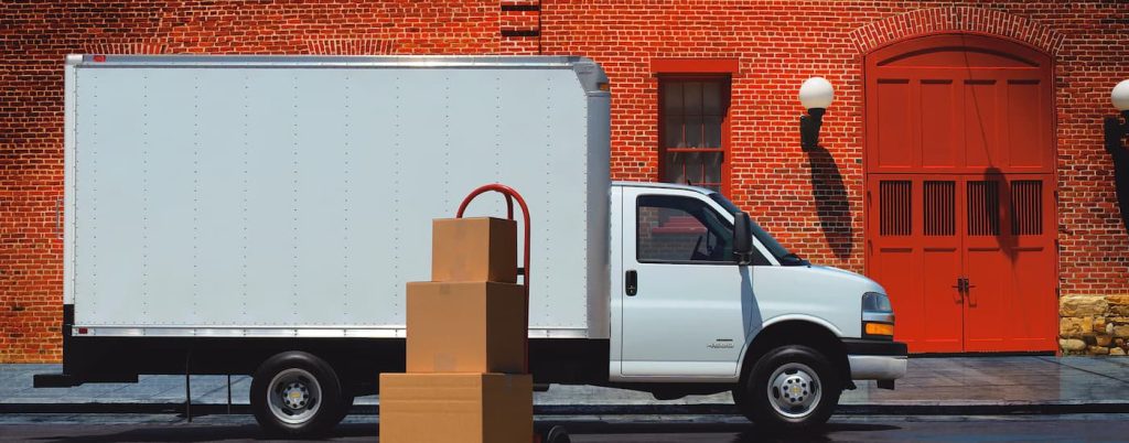 A white 2022 Chevy Express Cutaway is shown from the side next to a brick wall after viewing Chevy fleet vehicles for sale.