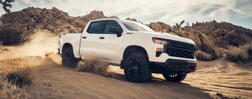 A white 2023 Chevy Silverado 1500 is shown from the side after leaving a Hondo Chevrolet dealer.