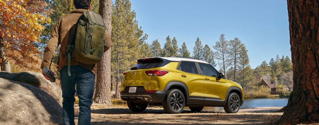 A yellow Chevy Trailblazer parked by a stream.