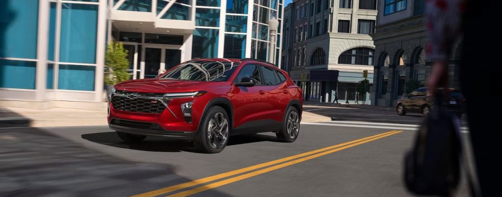 A red Chevy Equinox driving in the city.
