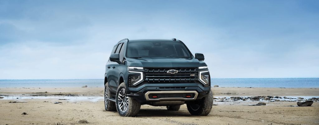 A blue 2025 Chevy Tahoe parked on a beach.
