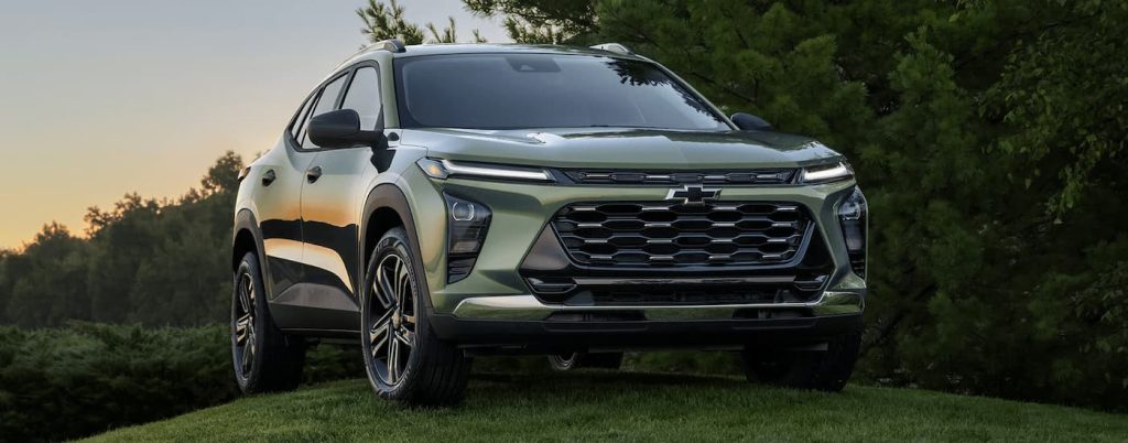 Green 2024 Chevy Trax parked on a grassy hill.