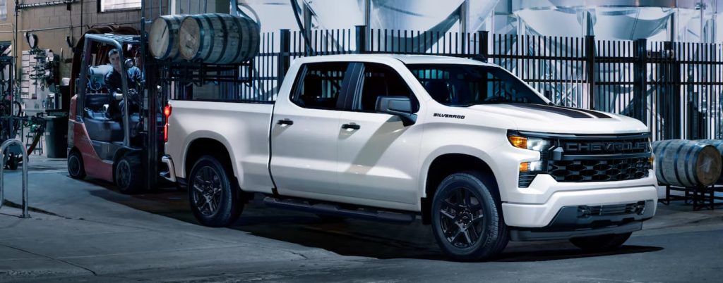 Side view of white Chevy Silverado 1500 waiting to be loaded.