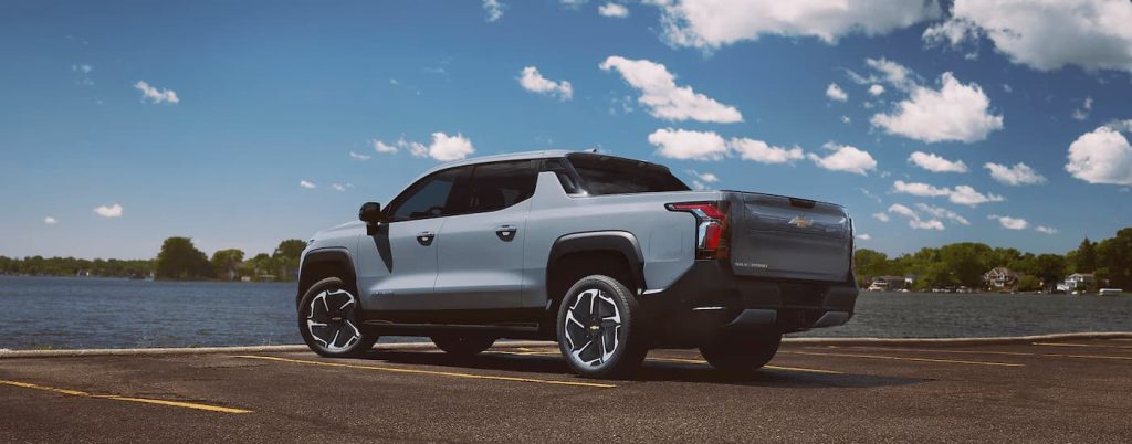 Side view of grey Chevy Silverado EV in a parking space.
