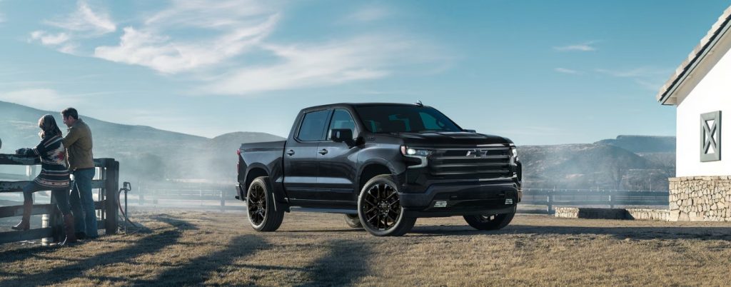 Black Chevy Silverado parked by a ranch house.