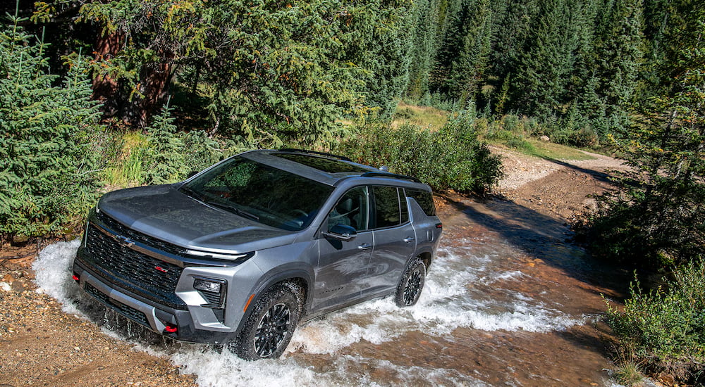 Silver 2025 Chevy Traverse driving through a puddle.