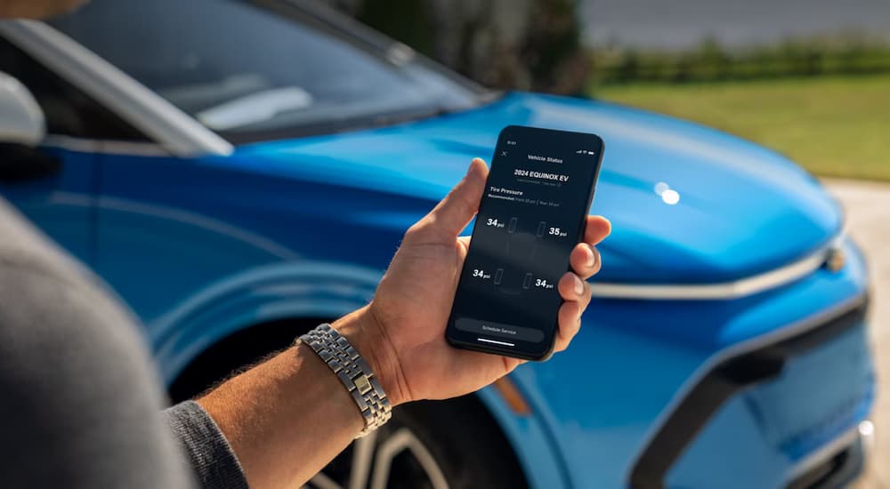 A hand is shown holding a smart phone shows the close up of the trailering features at a Moore Chevy dealer.