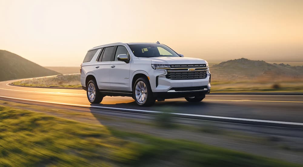 A white 2022 Chevy Suburban LT is shown driving on a highway after leaving a San Antonio Chevy Suburban dealer.
