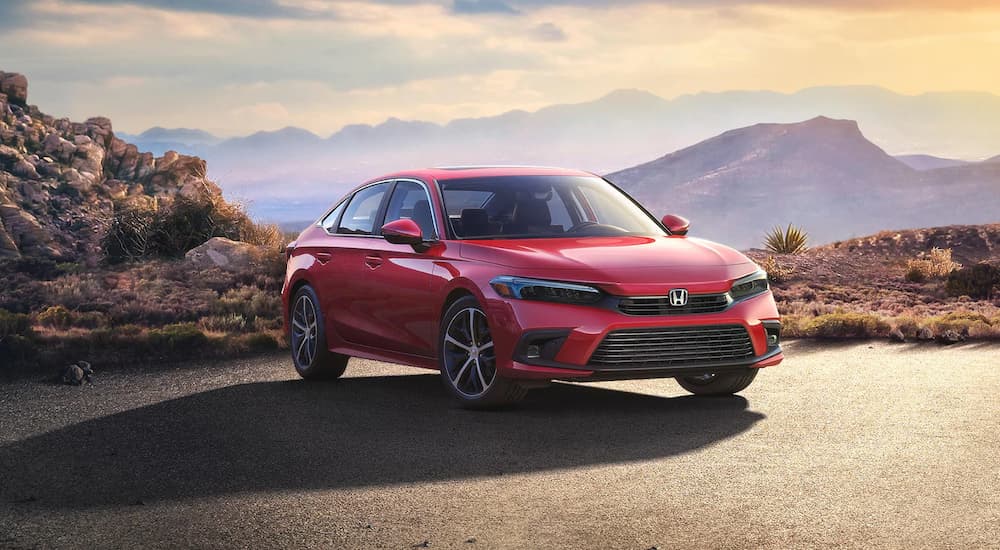 A popular used car for sale, a red 2022 Honda Civic Touring, parked on a mountain top.