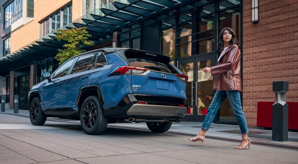Woman walking past a 2022 Toyota RAV4.