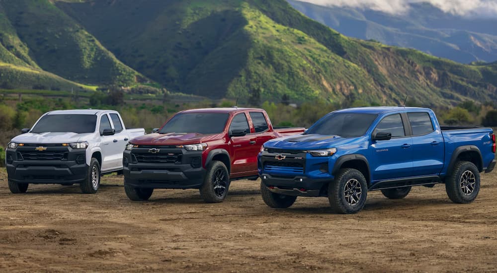Three 2025 Chevy Colorados parked on dirt.