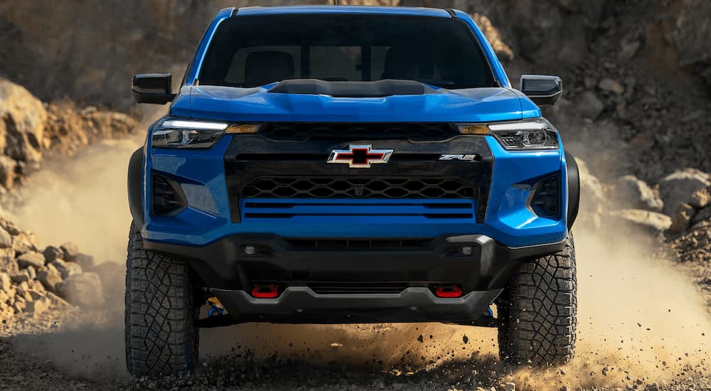 Blue 2025 Chevy Colorado ZR2 off-roading on a dusty trail.