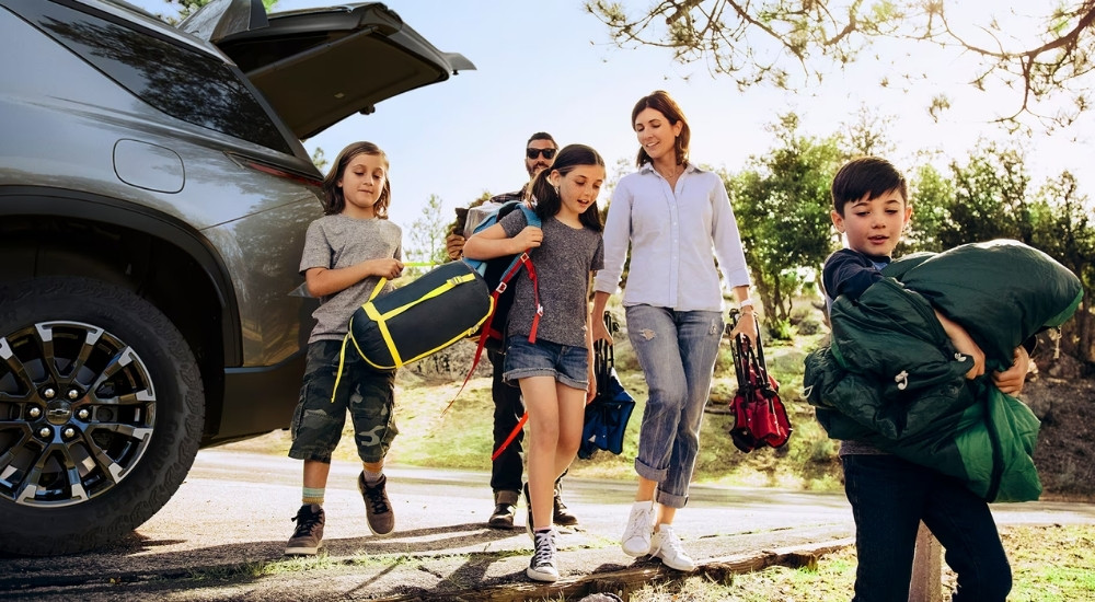 A family near a grey 2025 Chevy Traverse.