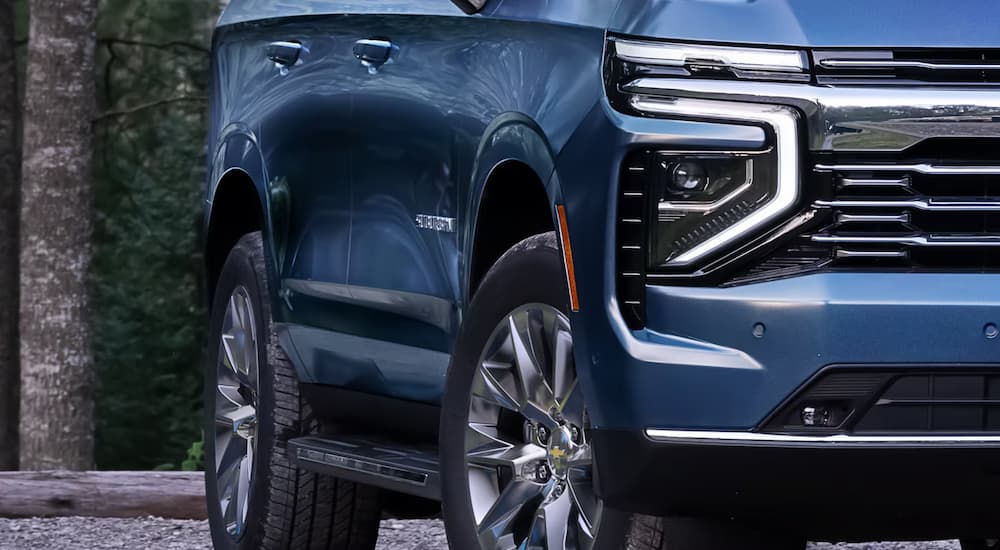 Front headlights and tire on a blue 2025 Chevy Suburban for sale near San Antonio