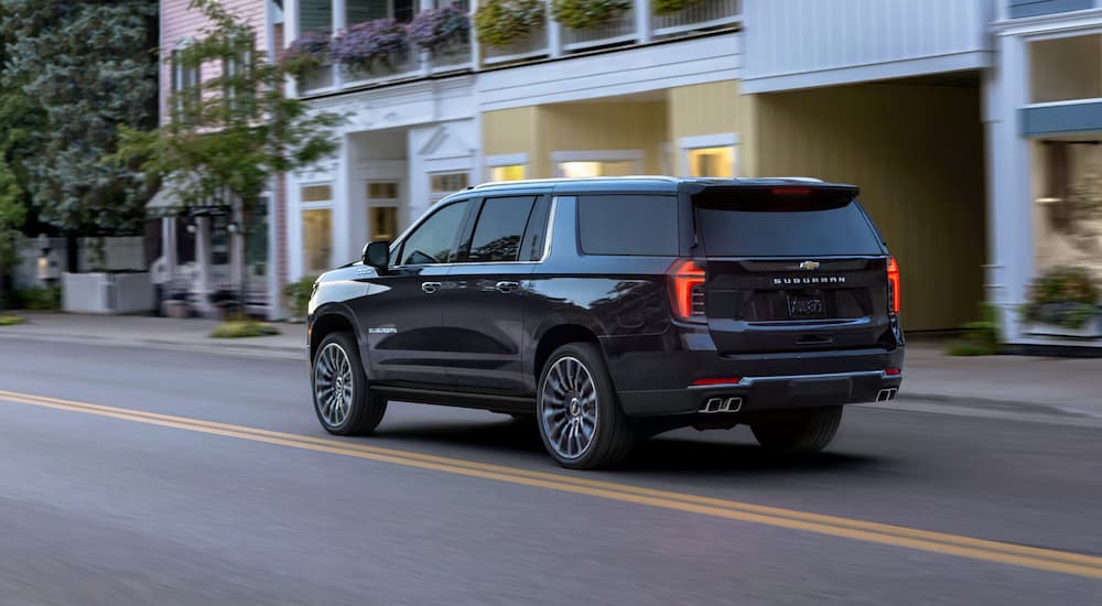 Black 2025 Chevy Suburban High Country driving through a town