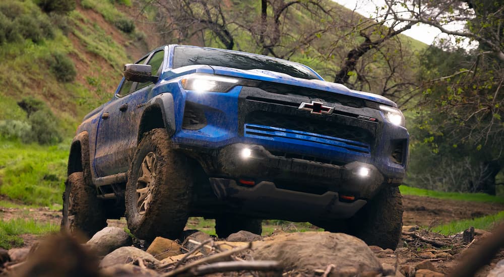 A blue 2026 Chevy Colorado ZR2 off-roading on rocks