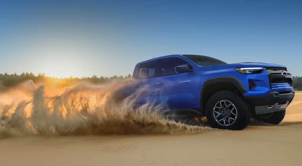 A blue 2026 Chevy Colorado off-roading and how it compares vs a 2026 GMC Canyon