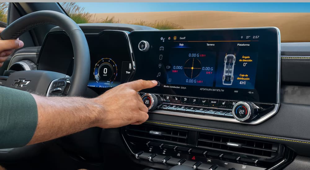 A man using the infotainment touchscreen in a 2026 Chevy Colorado