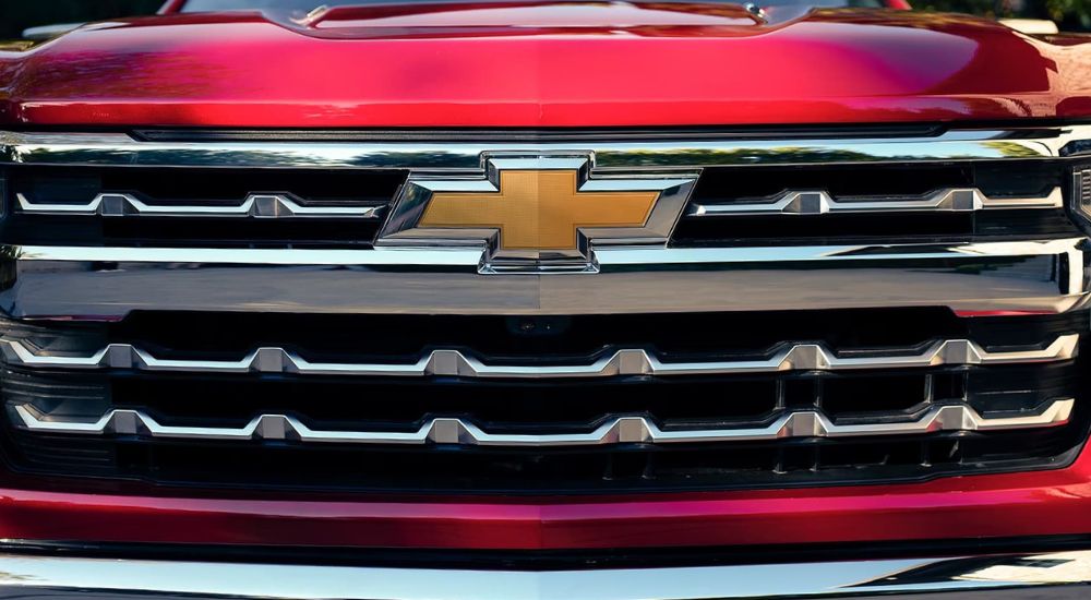Close-up on the grille and badge of a red 2026 Chevy Silverado 1500 LTZ.