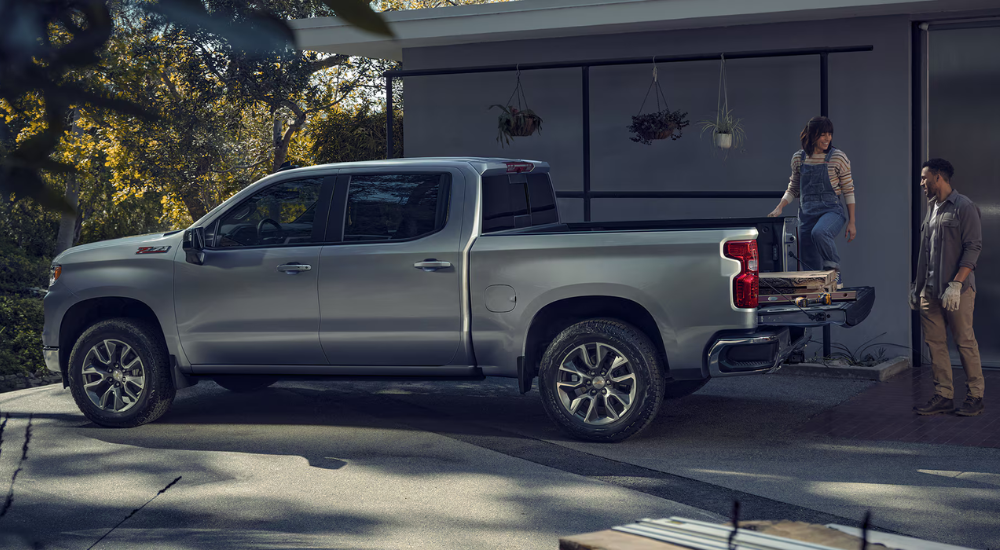 A couple unloads the bed of their silver 2026 Chevy Silverado 1500