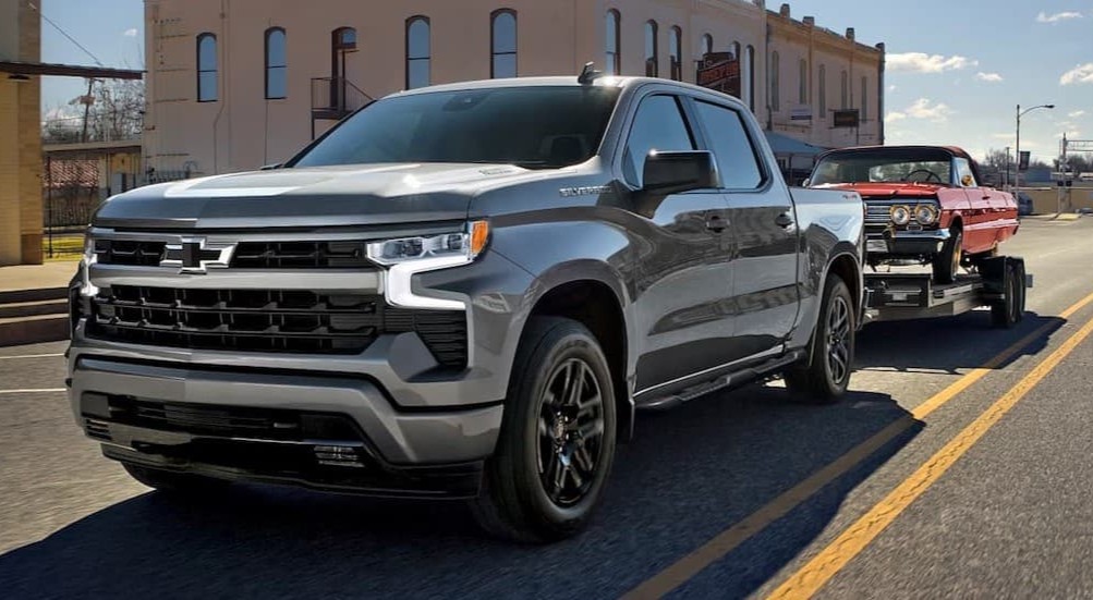 A silver 2026 Chevy Silverado 1500 towing a trailer.
