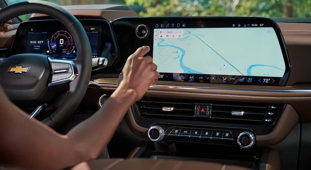 A person using the infotainment screen in a 2026 Chevy Tahoe.