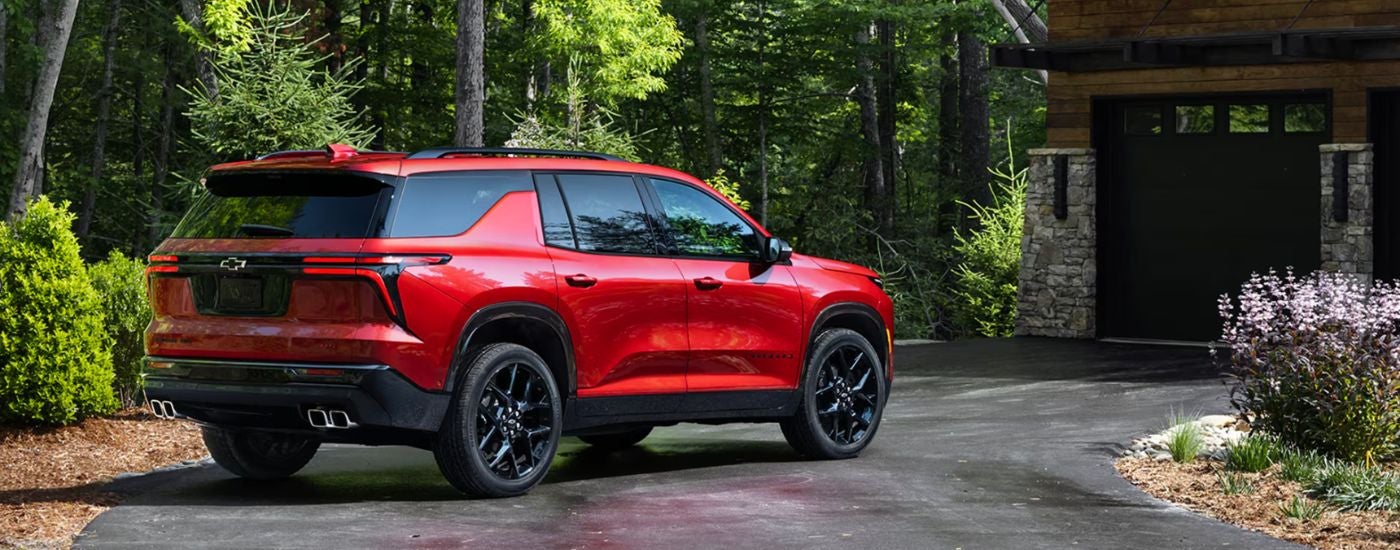A rear-facing red 2026 Chevy Traverse parked in a driveway.