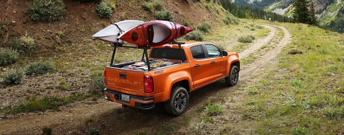 An orange 2022 Chevy Colorado Z71 driving on a trail.