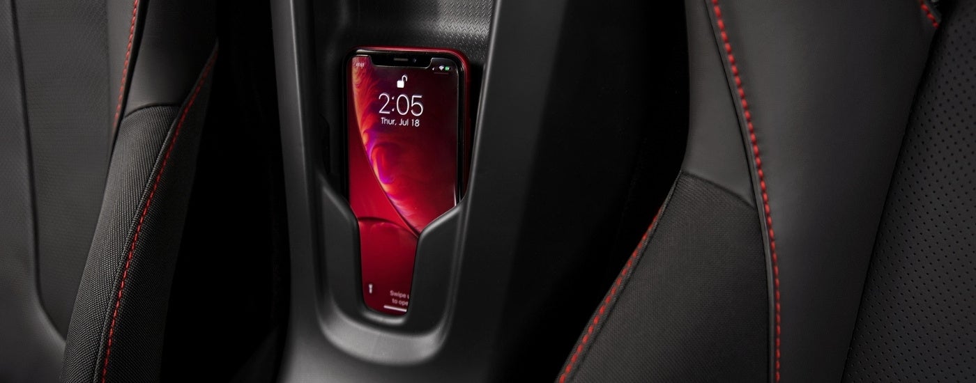 A phone in a storage holster between the seats in a 2022 Chevy Corvette.