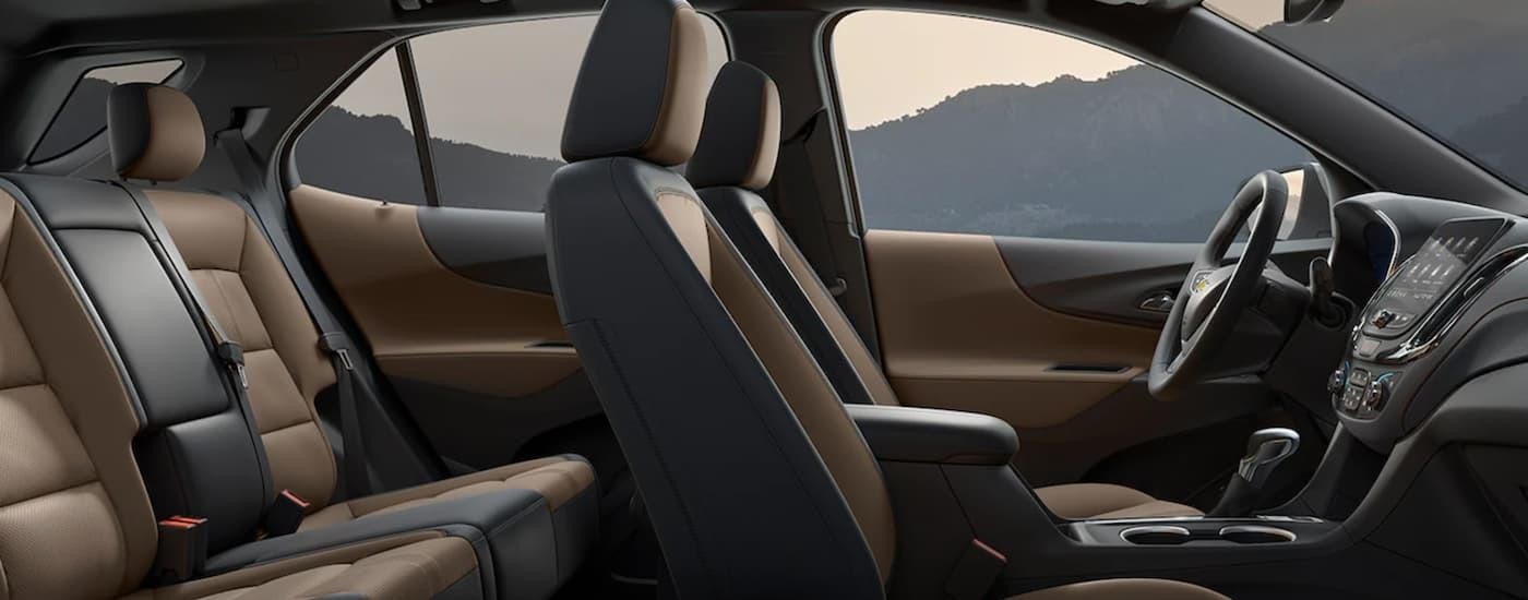 The black and brown interior of a 2022 Chevy Equinox shows two rows of seating from the side.