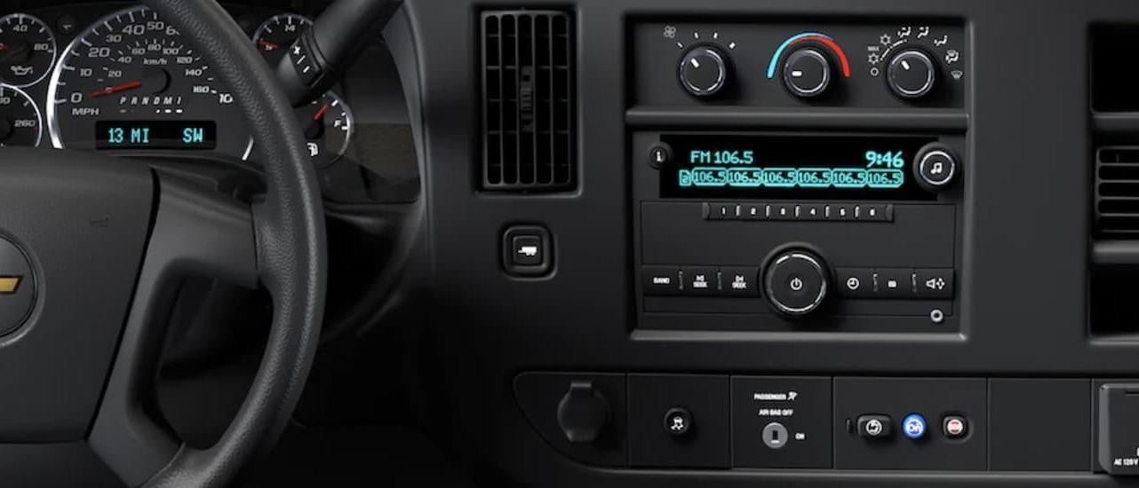 The grey interior of a 2022 Chevy Express Van shows the radio.