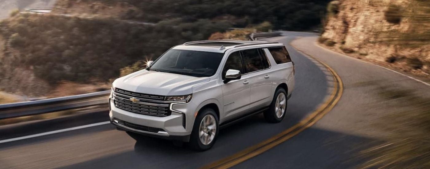 A white 2022 Chevy Suburban driving on a highway.