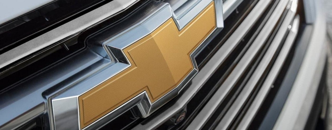 A close up shows the bowtie logo on the chrome grille on a 2022 Chevy Traverse.