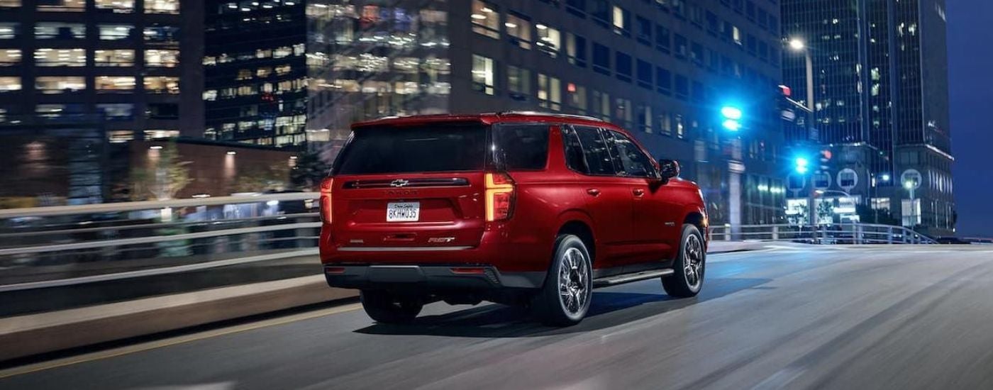 A red 2022 Chevy Tahoe RST driving through a city.