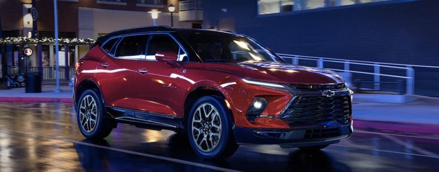 A red 2023 Chevy Blazer RS driving in a city.