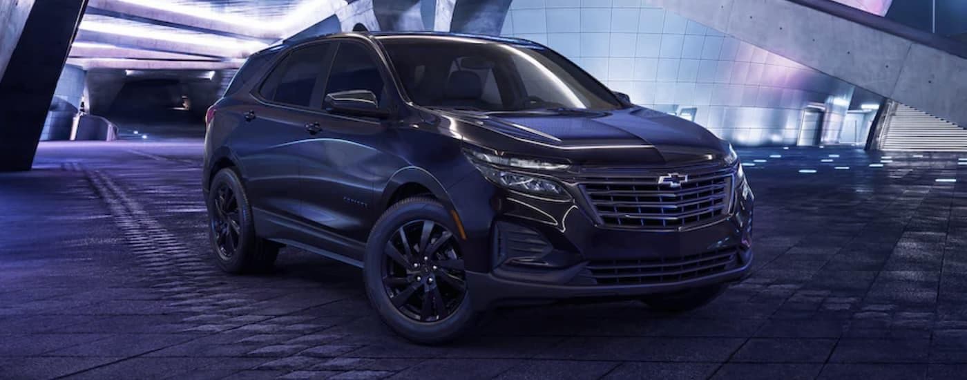 A black 2023 Chevy Equinox Midnight Edition parked at night.