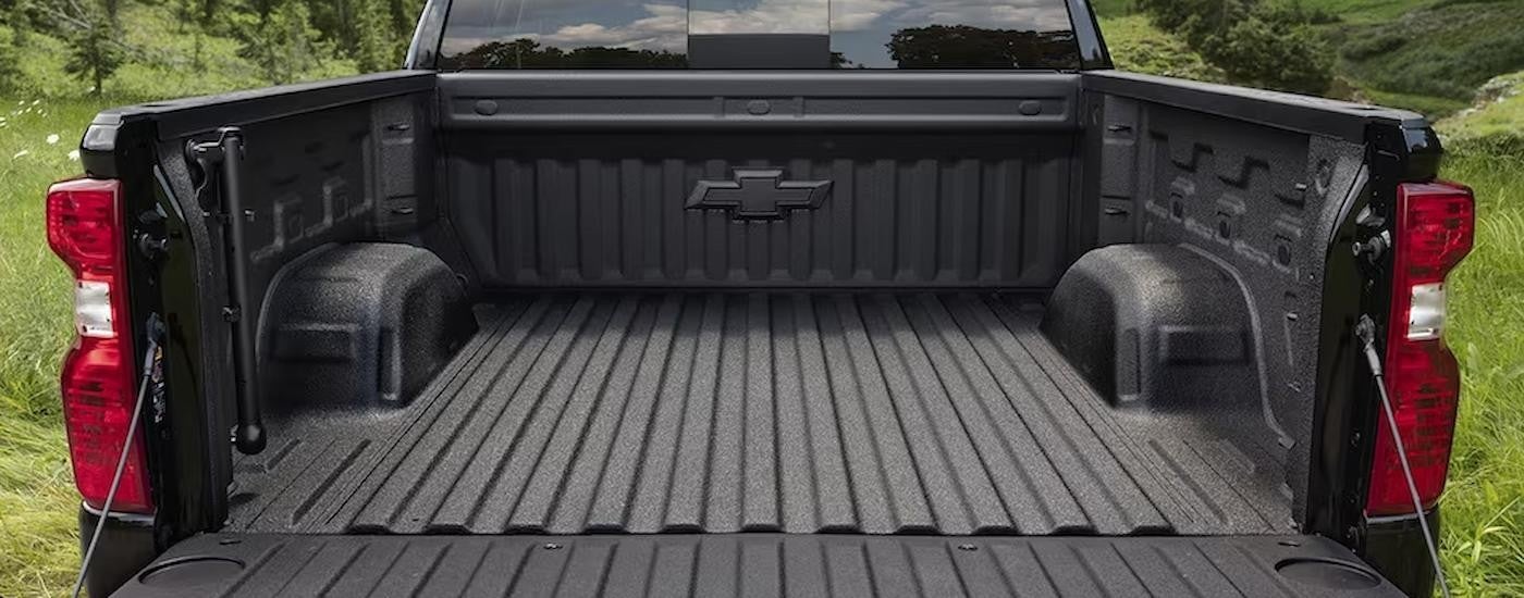 The bed of a red 2023 Chevy Silverado 1500 Custom is shown during a 2023 Chevy Silverado 1500 vs 2023 Toyota Tundra comparison.