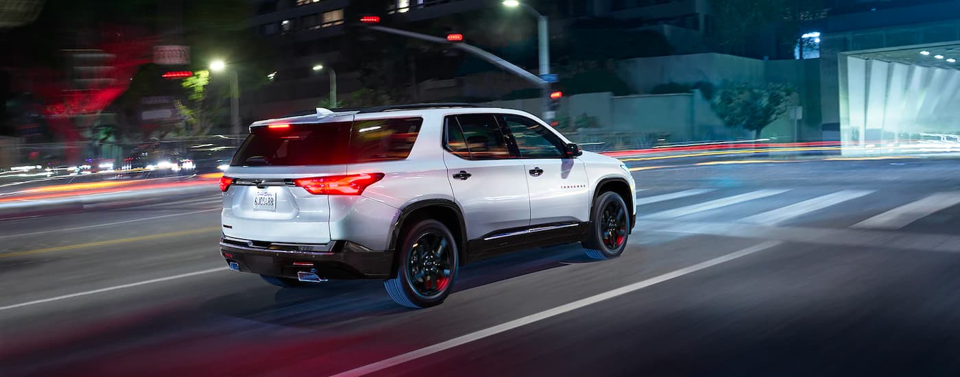 White 2023 Chevy Traverse driving through a city