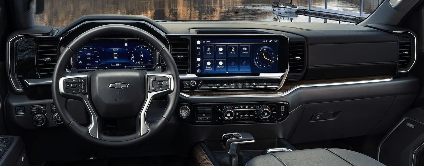 A close up of the steering wheel and center console of a 2024 Chevy Silverado 1500 are shown.