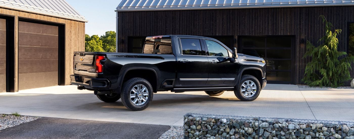 A black 2024 Chevy Silverado 3500 HD is parked on a driveway.