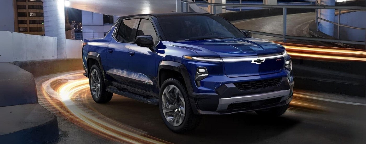 A blue 2024 Chevy Silverado EV RST driving on a ramp.