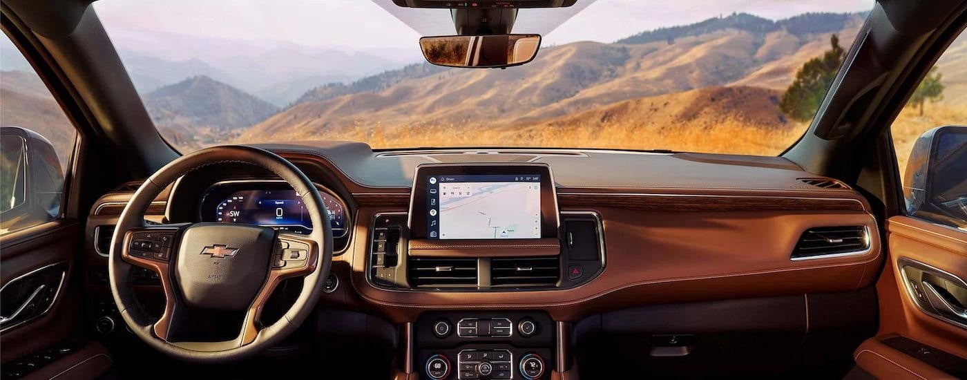 The tan interior of a 2024 Chevy Tahoe shows the dashboard and center console.