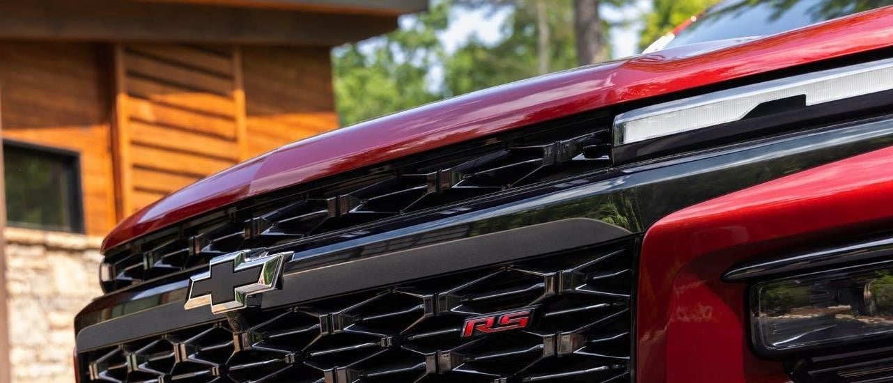 A close up shows the grille on a red 2024 Chevy Traverse RS.