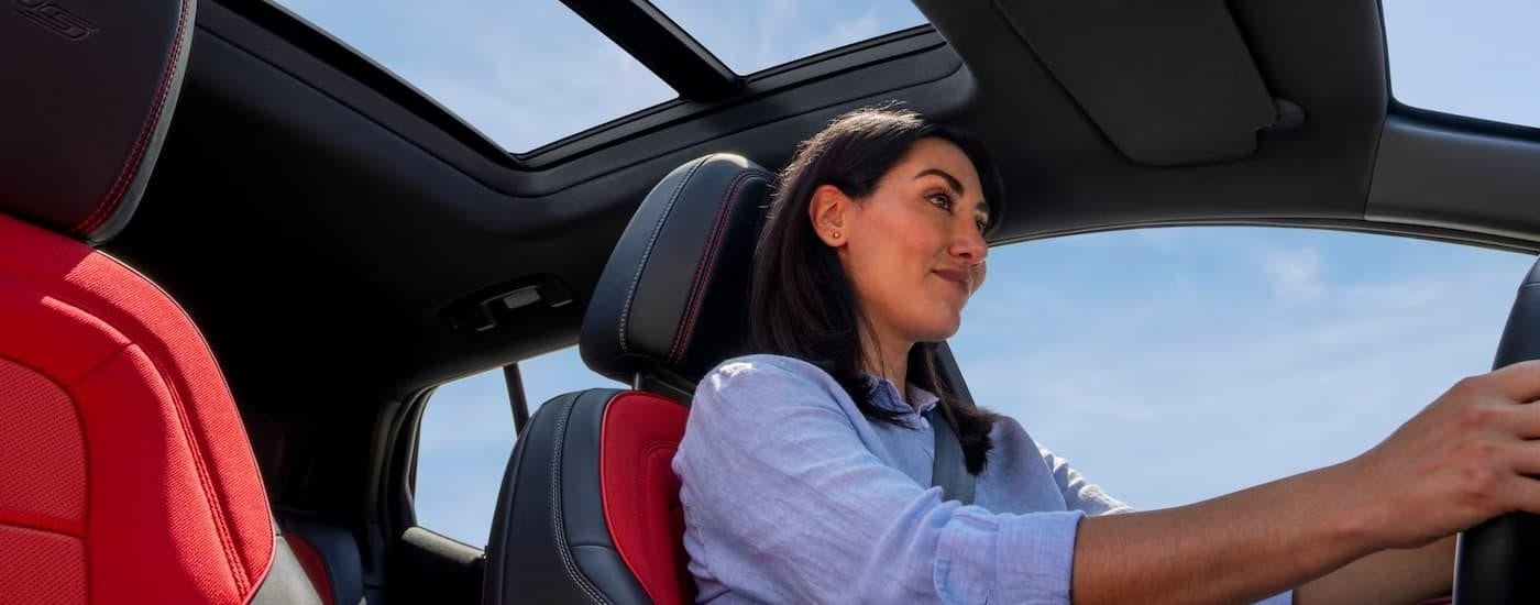 A woman is driving in a 2025 Chevy Equinox EV RS.