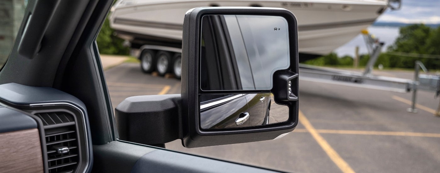 The side mirror on a black 2025 Chevy Silverado 2500 HD.