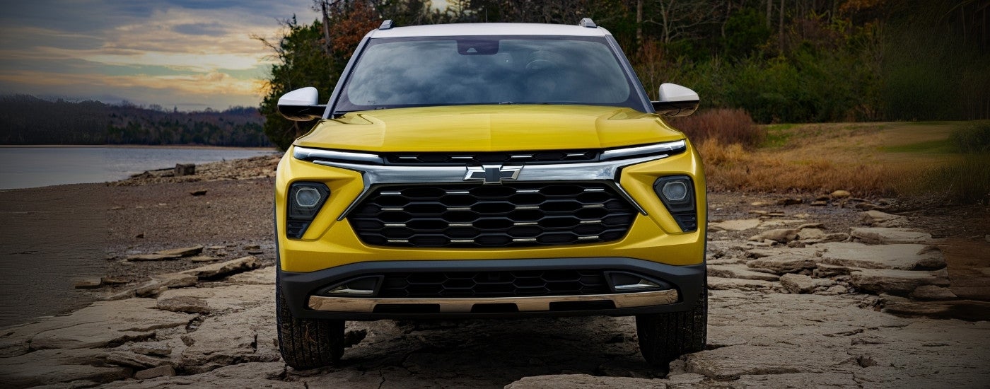 A yellow 2025 Chevy Trailblazer ACTIV parked on a shoreline.