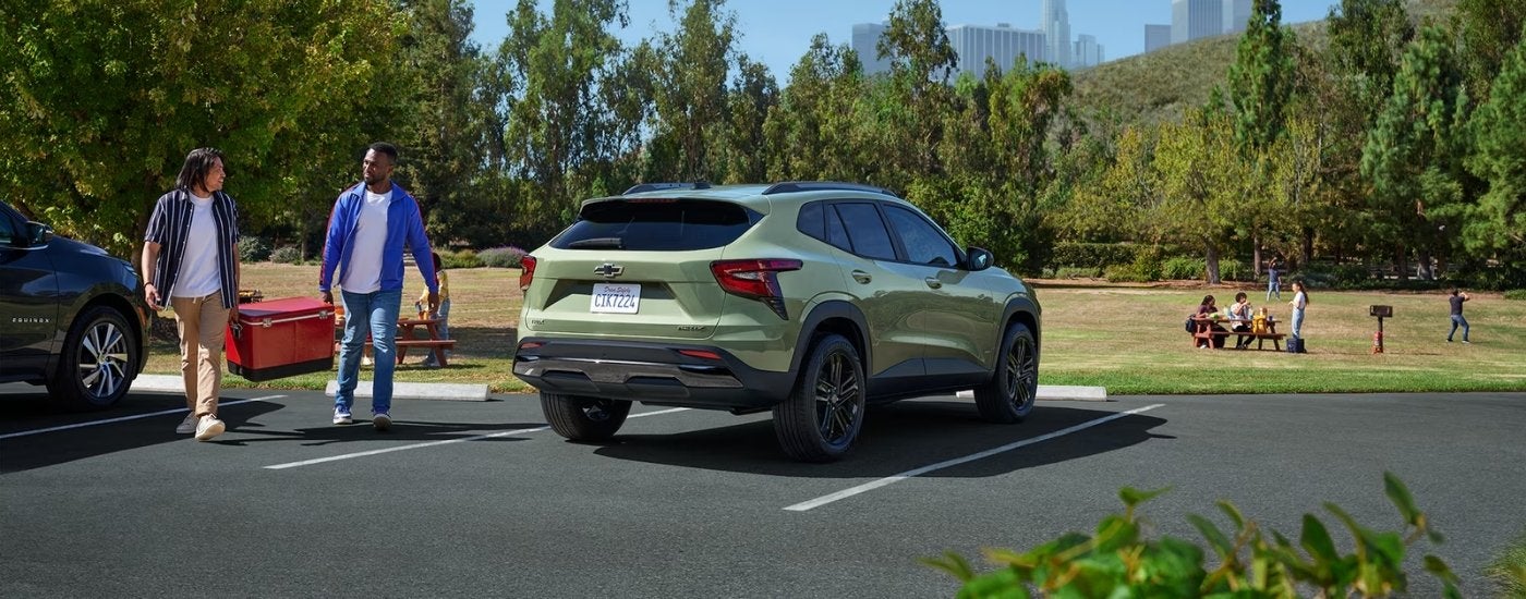 A green 2025 Chevy Trax ACTIV parked near a grassy park.