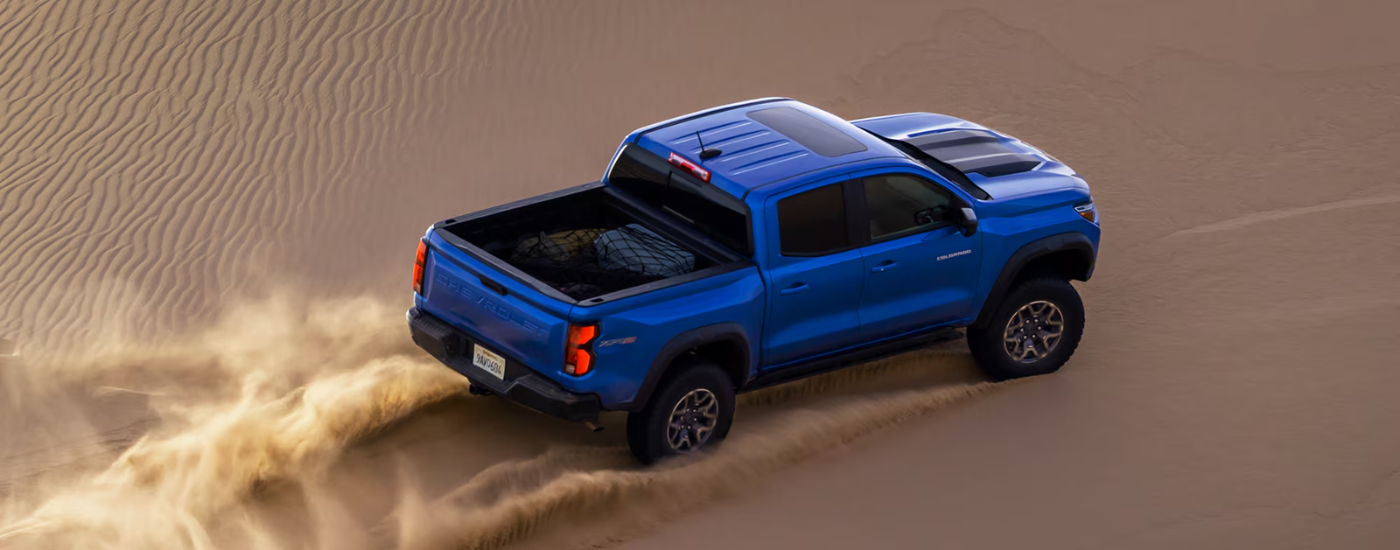 Blue 2026 Chevy Colorado ZR2 driving through a sand dune